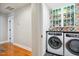 Modern laundry room with front-load washer and dryer, stylish cabinets and accent wall at 3332 Cheswick Dr, Raleigh, NC 27609