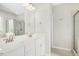 Bright bathroom features double sink vanity with white countertop and cabinets and a glass-enclosed shower at 361 W Copenhaver Dr, Clayton, NC 27527