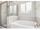 Bathroom featuring a soaking tub with tile surround and separate glass-enclosed shower at 361 W Copenhaver Dr, Clayton, NC 27527