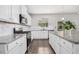 Modern kitchen features white cabinets, granite countertops, stainless steel appliances, and hardwood flooring at 361 W Copenhaver Dr, Clayton, NC 27527