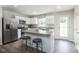 Bright kitchen features stainless steel appliances, a center island, and white cabinetry at 363 Tormore Dr, Sanford, NC 27330