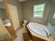 Bright bathroom with a soaking tub, neutral-colored walls, and tile floors creating a spa-like experience at 3954 Piney Grove Church Rd, Siler City, NC 27344