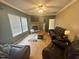 Relaxing living room with dark leather couches, stone fireplace and large windows offering natural light at 3954 Piney Grove Church Rd, Siler City, NC 27344