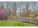 Spacious backyard featuring green grass, wooden fence, purple tree and views of the serene lake at 416 Collinsworth Dr, Clayton, NC 27527