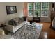 Bright living room with hardwood floors, a plush rug, and ample natural light from large windows at 4502 Pale Moss Dr, Raleigh, NC 27606