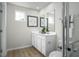 Bright bathroom featuring double sink vanity, modern mirrors, and a tiled shower for convenient living at 62 Furley St, Sanford, NC 27330