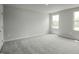 Bedroom with neutral gray carpet, white walls and two large windows at 66 Furley St, Sanford, NC 27330