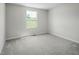 A sunlit bedroom with neutral walls and plush gray carpeting offers a serene space to relax at 66 Furley St, Sanford, NC 27330