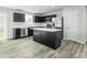 Well lit kitchen featuring dark cabinetry, stainless steel appliances, and an island with a white countertop at 66 Furley St, Sanford, NC 27330