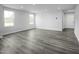 Bright, open-concept living room with white walls, gray wood floors, and recessed lighting at 66 Furley St, Sanford, NC 27330