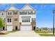 Attractive townhome featuring a two-car garage, stone accents, and a well-manicured lawn at 743 Parc Townes Dr # 36, Wendell, NC 27591