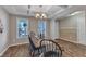 Bright dining room showcases wood-look floors and a chandelier with natural light from backyard-facing windows at 78 Parkview Ln, Lillington, NC 27546