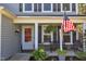 Inviting front porch featuring a cozy bench, potted plants, and an American flag, creating a welcoming entrance at 78 Parkview Ln, Lillington, NC 27546