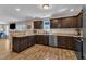 Modern kitchen features dark cabinetry, stainless steel appliances, and a large counter overlooking a dining space at 78 Parkview Ln, Lillington, NC 27546
