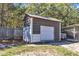 The metal-sided storage shed with a roll-up door offers secure storage space in the backyard at 78 Parkview Ln, Lillington, NC 27546