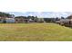 Expansive backyard featuring green space, with a partial view of the houses, all enclosed by a wrought iron fence at 80 Greta Ln, Henderson, NC 27537