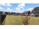Large, level backyard showcasing a well-maintained lawn, brick home, and a screened porch at 80 Greta Ln, Henderson, NC 27537