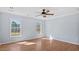 Empty bedroom featuring hardwood floors, two windows, ceiling fan, and neutral paint color at 80 Greta Ln, Henderson, NC 27537