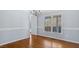 Dining room with hardwood floors, chair rail, and picture window offering natural light, with view to kitchen at 80 Greta Ln, Henderson, NC 27537