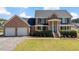 Charming two-story brick home featuring an attached two-car garage and a well-manicured front yard at 80 Greta Ln, Henderson, NC 27537