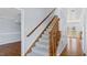 Carpeted staircase with wooden banister, leading to upper level with views of adjacent rooms at 80 Greta Ln, Henderson, NC 27537