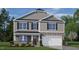 Charming two-story home with stone accents, gray siding, black shutters, and a manicured front yard at 816 Canis Minor Rd, Wendell, NC 27591