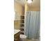 Neat bathroom with storage shelves, a shower with blue curtain, and neutral colors at 860 Bear Rd, Benson, NC 27504