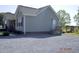 Exterior view of home featuring gravel driveway, tidy landscaping, and access to back entrance at 860 Bear Rd, Benson, NC 27504