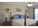 Cozy main bedroom with a wooden four-poster bed, ceiling fan, and natural light at 860 Bear Rd, Benson, NC 27504