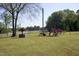 Spacious yard featuring mature trees, lush greenery, and relaxing outdoor bench at 860 Bear Rd, Benson, NC 27504