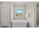 Bright bathroom with a soaking tub and natural light from a large window at 10119 Second Star Ct, Raleigh, NC 27613