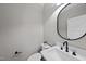 Modern half bathroom featuring sleek fixtures and a stylish round mirror at 10119 Second Star Ct, Raleigh, NC 27613