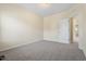 This bedroom features neutral walls, plush carpet, and a door leading to another room at 1019 Thoughtful Spot Ln, Durham, NC 27703