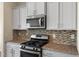 Bright kitchen featuring granite countertops, stainless appliances, and gray cabinets at 1019 Thoughtful Spot Ln, Durham, NC 27703