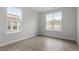 Bright bedroom with two large windows, neutral paint, and wood-look flooring, offering a serene space at 104 Black Walnut Dr # 202, Garner, NC 27529