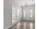 Spacious foyer with hardwood floors, glass french doors and modern chandelier at 104 Black Walnut Dr # 202, Garner, NC 27529
