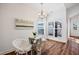 Bright breakfast nook features modern chandelier, wood floors, and natural light from large windows at 1064 Blue Bird Ln, Wake Forest, NC 27587