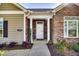 Home showcasing a stone front facade with columns, a glass front door, and manicured landscaping at 1064 Blue Bird Ln, Wake Forest, NC 27587
