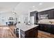 Stylish kitchen with a granite island, stainless steel appliances, and dark cabinets, seamlessly connected to the living area at 1064 Blue Bird Ln, Wake Forest, NC 27587