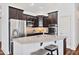 Modern kitchen featuring dark wood cabinetry, stainless steel appliances, and a spacious island with granite countertops at 1064 Blue Bird Ln, Wake Forest, NC 27587