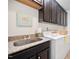 Well-equipped laundry room with granite countertops, stainless steel sink, and ample cabinet space at 1064 Blue Bird Ln, Wake Forest, NC 27587