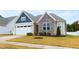 Inviting front exterior featuring a two-car garage, stone accents, and a well-manicured lawn at 124 Alta Crest Ln, Garner, NC 27529