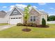 Beautiful exterior featuring a two-car garage, stone accents, and a professionally landscaped front yard at 124 Alta Crest Ln, Garner, NC 27529