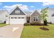 Charming home featuring a two-car garage and stone accents, complemented by a well-maintained lawn and landscape at 124 Alta Crest Ln, Garner, NC 27529