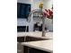 Close-up of a stainless steel kitchen faucet and sink with water running in a modern kitchen at 124 Alta Crest Ln, Garner, NC 27529