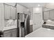 Modern kitchen with gray cabinets, stainless steel refrigerator, quartz countertops, and tile backsplash at 124 Alta Crest Ln, Garner, NC 27529
