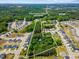 Aerial view showing approximate property lines, lush greenery, water features, and homes at 1355 Bowling Road, Fuquay Varina, NC 27526