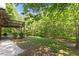 Green backyard with a patio and lush surrounding trees at 1355 Bowling Road, Fuquay Varina, NC 27526