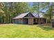 Large barn structure featuring multiple garage doors and covered sheds at 1355 Bowling Road, Fuquay Varina, NC 27526