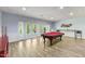 Spacious basement with a billiard table, access to the backyard and wood-look flooring at 1355 Bowling Road, Fuquay Varina, NC 27526